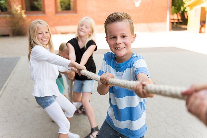 Eine Gruppe von Kindern spielt Tauziehen in der Schulbetreuung der AWO in Mönchengladbach.