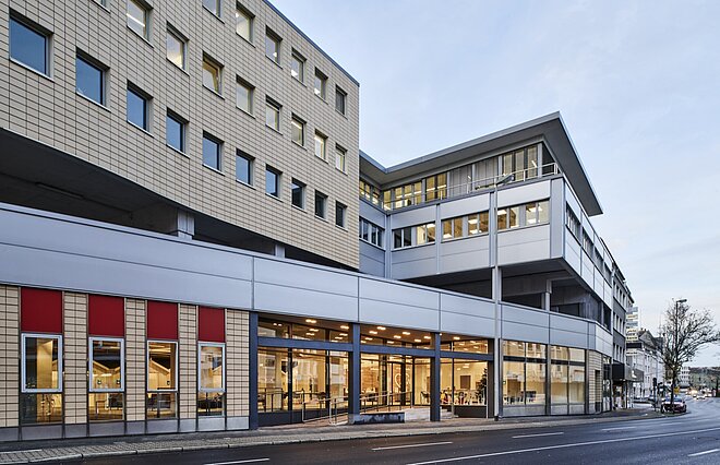 Ein modernes Bürogebäude mit Glasfassade. Das L64 der AWO Mönchengladbach von der Straße aus.